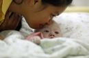 Gammy, a baby born with Down's Syndrome, is kissed by his surrogate mother in Chonburi province