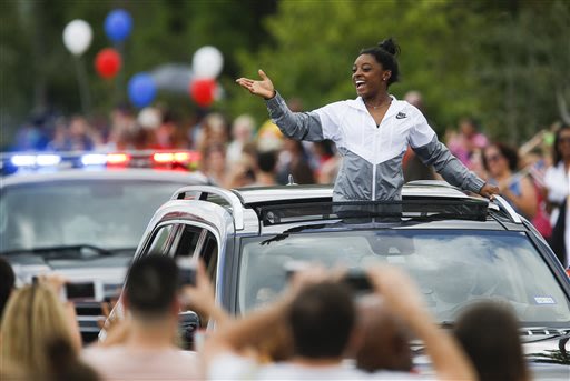 Simone Biles acknowledges the crowd during a welcome home parade in Texas. (AP)
