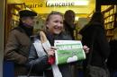 A woman poses with her copy of Charlie Hebdo as it goes on sale in London