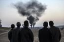 People watch as smokes rises from the town of Kobane on October 26, 2014, at the Turkish border near the southeastern village of Mursitpinar