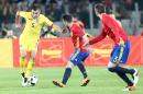 Spain's Mario Perez, center, and Gerard Pique challenge the ball with Romania's Ovidiu Stefan Hoban during a friendly soccer match between Romania and Spain in Cluj, Romania, Sunday, March 27, 2016. (AP Photo/Mircea Rosca)