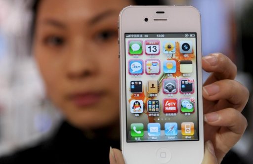 A store employee holds up an iPhone 4S at a shop in Hangzhou, China's Zhejiang province, on January 13, 2012