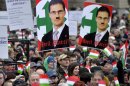 Participants hold a portrait of Hungarian lawmaker of Jobbik party Marton Gyongyosi showing him with a Hitler moustache as thousands of people attend a protest called Mass Demonstration Against Nazism in front of the Parliament building, unseen, in Budapest, Hungary, Sunday, Dec. 2, 2012. The protest has been provoked by MP Gyongyosi who demanded a list on Jewish Hungarians who are members of the Parliament or the government. (AP Photo/MTI, Laszlo Beliczay)