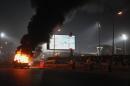 A pickup truck bursts into flames as a riot breaks out outside of a soccer match between Egyptian Premier League clubs Zamalek and ENPPI at Air Defense Stadium in a suburb east of Cairo, Egypt, Sunday, Feb. 8, 2015. The riot broke out Sunday night outside of the major soccer game, with a stampede and fighting between police and fans killing at least 22 people, authorities said. (AP Photo/Ahmed Abd El-Gwad, El Shorouk newspaper) EGYPT OUT