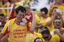 An Aucas soccer fan, wearing a T-shirt that reads in Spanish "Shake, daddy's back" and clutching a heart shaped doll in his team's colors cries after Aucas scored the winning point that moved them back into the top soccer division, Serie A, in Quito, Ecuador, Sunday, Nov. 16, 2014. The Aucas Sociedad Deportiva football club, founded in 1945, hasn't played in Ecuador's top division soccer for the last eight years, and is the only team from the capital that failed to qualify for the Copa Libertadores. Aucas has never won a championship, but the team's fans, spanning all generations, fill stadiums to cheer them on, and say Aucas is not just a team, but a passion. The team's Sunday victory finally put them back in the top division. (AP Photo/Dolores Ochoa)