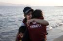 A migrant woman hugs her children, moments after arriving on a dinghy on the Greek island of Kos
