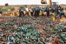 Sharia enforcers destroy thousands of bottles of beer outside northern Nigeria's largest city of Kano on November 27, 2013