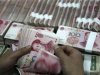An employee counts yuan banknotes at a branch of the Industrial and Commercial Bank of China in Huaibei