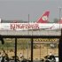 People are silhouetted as Kingfisher Airlines' aircrafts are seen parked at an airport in New Delhi