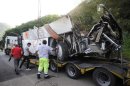 The wreckage of a coach which plunged off a viaduct is loaded onto a trailer near Avellino