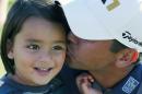 Jason Day of Australia, kisses his son Dash, after winning the BMW Championship golf tournament at Conway Farms Golf Club, Sunday, Sept. 20, 2015, in Lake Forest, Ill. (AP Photo/Charles Rex Arbogast)