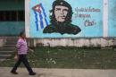 A man walks past near an image of revolutionary hero Ernesto "Che" Guevara in Havana