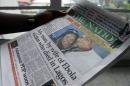 A man reads a newspaper featuring a front page story on the death of Liberian diplomat Patrick Sawyer (pictured with his wife Decontee) who died of the Ebloa virus in Lagos on July 30, 2014