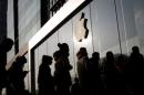 People line up at an Apple store shortly before it opens in Beijing
