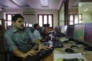 Brokers trade on their computer terminals at a stock brokerage firm in Mumbai