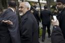 Iranian Foreign Minister Javad Zarif talks to members of the media while walking through a courtyard at the Beau Rivage Palace Hotel during an extended round of talks in Lausanne