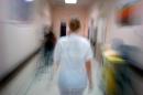 A hospital worker walks down a hallway