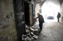 A man inspects burnt books on January 4, 2014 in north Lebanon's majority Sunni city of Tripoli a day after a decades-old library owned by a Greek Orthodox priest was torched
