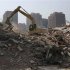 An excavator is used to demolish a building near a residential complex in Zhengzhou