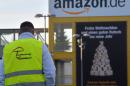 A man wearing a high-visibility vest reading "Protect Union Rates" is pictured outside an Amazon site in Leipzig, eastern Germany, on December 15, 2014