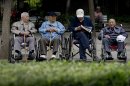 In this Thursday, May 23, 2013 photo, a group of elderly men take a rest on their wheelchairs at a park in Beijing. New wording in the law requiring people to visit or keep in touch with their elderly parents or risk being sued came into force Monday, July 1, 2013, as China faces increasing difficulty in caring for its aging population. (AP Photo/Andy Wong)
