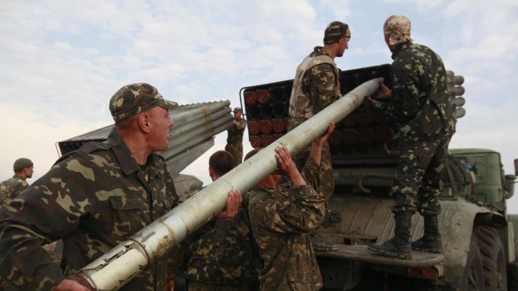 Ukrainian soldiers load a Grad missile during fighting with pro-Russian separatists close to Luhansk, eastern Ukraine, Monday, Aug. 18, 2014. Dozens of civilians were killed Monday when separatist rebels shelled a convoy of refugees trying to flee war-torn eastern Ukraine, a top Ukrainian official said. A top rebel chief said no such attack had occurred. (AP Photo/Petro Zadorozhnyy)