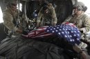 FILE- In this file photograph made on July 29, 2010, upon landing after a helicopter rescue mission, Tech. Sgt. Jeff Hedglin, right, an Air Force Pararescueman, or PJ, drapes an American flag over the remains of the first of two U.S. soldiers killed minutes earlier in an IED attack, assisted by fellow PJs, Senior Airman Robert Dieguez, center, and 1st Lt. Matthew Carlisle, in Kandahar province, southern Afghanistan. U.S. military deaths in Afghanistan have surpassed 2,000, a grim reminder that a war which began nearly 11 years ago shows no signs of slowing down despite an American decision to begin the withdrawal of most of its combat forces. (AP Photo/Brennan Linsley, File)