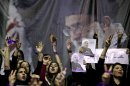 Female supporters of the Iranian presidential candidate, Hasan Rowhani, chant slogans, under a portrait of the Supreme Leader Ayatollah Ali Khamenei, during a campaign rally in Tehran, Iran, Saturday, June 8, 2013. Rowhani, a candidate in next week's presidential elections, says he will reset Iran's economy and will reverse President Mahmoud Ahmadinejad's foreign policy directions if elected. (AP Photo/Ebrahim Noroozi)