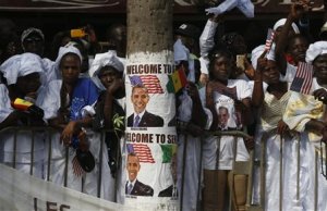 Senegalese women watch as U.S. President Obama's motorcade …