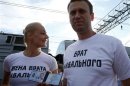 Anti-corruption blogger Alexei Navalny holds his Moscow mayor candidate registration certificate as his wife Yulia looks on in Moscow