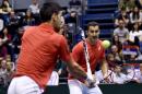 Serbia's tennis player Nenad Zimonjic (rear C) looks at his teammate Novak Djokovic (L) as he returns a shot during the Davis Cup World Group first round double match between Serbia and Kazakhstan in Belgrade, on March 5, 2016