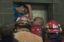 A woman is rescued from being trapped inside a wall of the parking garage at the Gretchen Kafoury Commons in SW Portland, Ore., Wednesday, Jan. 16, 2013. Portland firefighters worked for over three and a half hours cutting her free. (AP Photo/The Oregonian, Brent Wojahn)