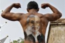 File photo of devotee showing his back with an image of Gujarat CM Modi as he flexes his muscles during the 134th annual Rath Yatra in Ahmedabad