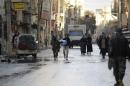 Free Syrian Army fighters walk along a street in Deir al-Zor
