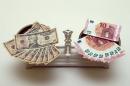 A picture illustration shows U.S. Dollar and Euro banknotes on a pair of scales in Vienna