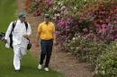 Erik Compton walks with his caddie down the sixth fairway during a practice round for the Masters golf tournament Monday, April 6, 2015, in Augusta, Ga. (AP Photo/Charlie Riedel)