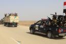 Iraqi government forces and local tribal fighters drive on the highway between the city of Ramadi and the town of Rutba as they take part in an operation to retake Rutba from the Islamic State jihadist group on May 16, 2016