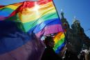 FILE - In this Wednesday, May 1, 2013, file photo, gay rights activists carry rainbow flags as they march during a May Day rally in St. Petersburg, Russia. When the Sochi Winter Olympics begin on Friday, Feb. 7, 2014 many will be watching to see whether Russia will enforce its law banning gay 