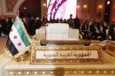 The Syrian opposition flag is seen in front of the seat of the Syrian delegation at the opening the Arab League summit in Doha