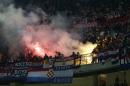 Croatia's supporters light their flares during the Euro 2016 qualifying soccer match between Italy and Croatia, at the San Siro stadium in Milan, Italy, Sunday, Nov. 16, 2014. The match was temporarily suspended following the launch of flares and clashes with Italian riot police on the stands. (AP Photo/Antonio Calanni)