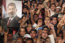 Members of the Muslim Brotherhood and supporters of Egypt's President Mursi react after the Egyptian army's statement was read out on state TV, at the Raba El-Adwyia mosque square in Cairo