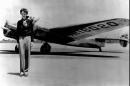 FILE - In this undated file photo, Amelia Earhart stands next to a Lockheed Electra 10E, before her last flight in 1937 from Oakland, Calif., bound for Honolulu on the first leg of her record-setting attempt to circumnavigate the world westward along the Equator. American aviator Earhart's disappearance in 1937 is among aviation's most enduring mysteries. Earhart, the first female pilot to cross the Atlantic Ocean, vanished over the Pacific with Fred Noonan during an attempt to circumnavigate the globe. Seven decades later, people are still transfixed with the mystery. Theories range from her simply running out of fuel and crashing to her staging her own disappearance and secretly returning to the U.S. to live under another identity. (AP Photo/File)