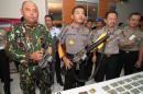 Indonesian police officials display firearms and ammunitions seized during a raid against suspected Islamic militants in Poso district on Sulawesi island on May 26, 2015