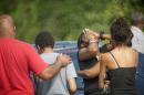 People comfort each other after a shooting in Fayetteville, N.C., Wednesday, July 30, 2014. A domestic dispute erupted into a gun battle with deputies Wednesday at a North Carolina mobile home park, leaving three people dead and three officers wounded, officials said. (AP Photo/The Fayetteville Observer, Cindy Burnham) MANDATORY CREDIT