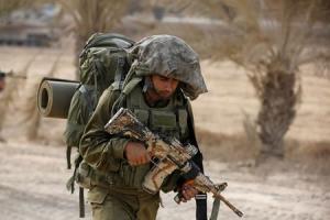 An Israeli soldier walks outside the Gaza Strip