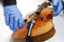 A French chemist checks a Stradivarius violin at the restoration and research laboratory of the Musee de la Musique in Paris, on December 3, 2009