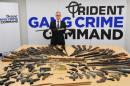 A picture received from the Metropolitan Police Service on November 25, 2014 shows Detective Superintendent Gordon Allison posing with a selection of firearms and ammunition handed in to police stations across London on November 23, 2014
