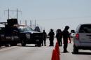 A federal police officer inspect a vehicle at a security checkpoint near a prison in Ciudad Juarez where Mexican drug boss Joaquin "Chapo" Guzman has been moved from his jail in central Mexico