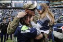 United States Army Sgt. Zach Ames, center, who has been on a one-year deployment to Afghanistan, surprises his wife, Bri Ames, left, and their daughter Emersyn, right, with a reunion prior to an NFL football game between the New York Jets and the Seattle Seahawks on Veterans Day, Sunday, Nov. 11, 2012, in Seattle. (AP Photo/Elaine Thompson)