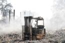 A burned forklift stands in the middle of a destroyed property during Clayton Fire at Lower Lake in California